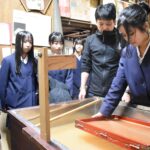 上田さんの指導で卒業証書づくりに励む6年生=岡山県津山市で