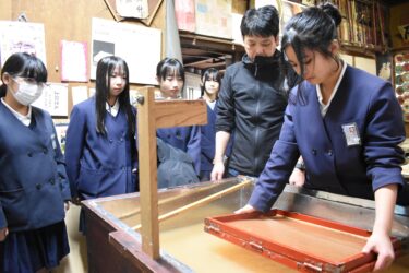 上田さんの指導で卒業証書づくりに励む6年生=岡山県津山市で