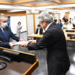 優秀店の標識を受け取る代表者（左）=岡山県津山市で