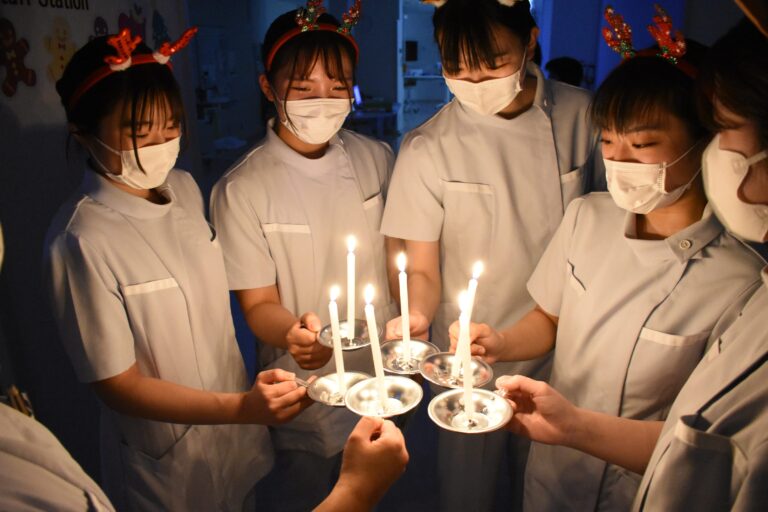 キャンドルの灯（ともしび）を分け合う学生たち=岡山県津山市川崎の津山中央看護専門学校で