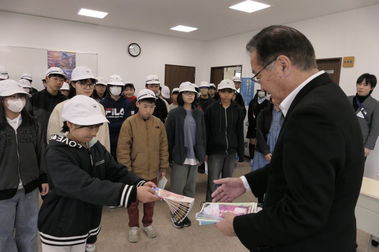 完成したパンフレットを河本会長に手渡す6年生＝岡山県津山市で