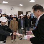 完成したパンフレットを河本会長に手渡す6年生＝岡山県津山市で