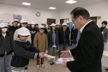 完成したパンフレットを河本会長に手渡す6年生＝岡山県津山市で