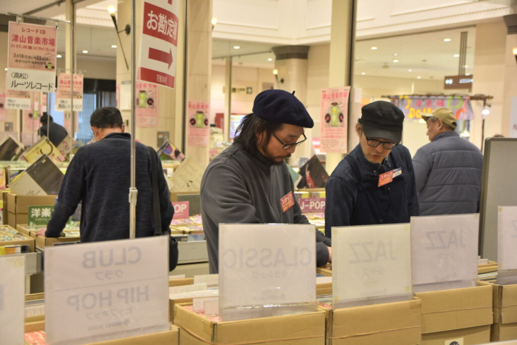 レコードを確認する秀島さん（右）