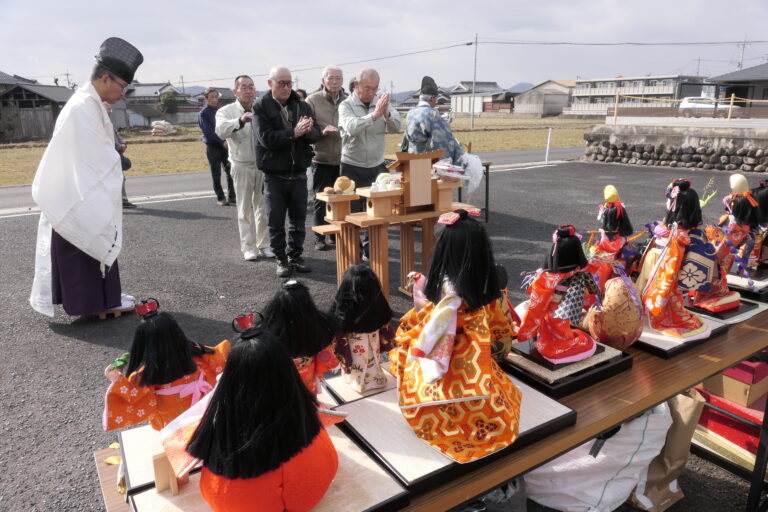 人形に感謝の気持ちを込めて手を合わせる地域住民ら=岡山県津山市で