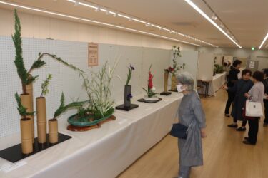 絵画や生け花などの展示作に見入る来場者=岡山県津山市で