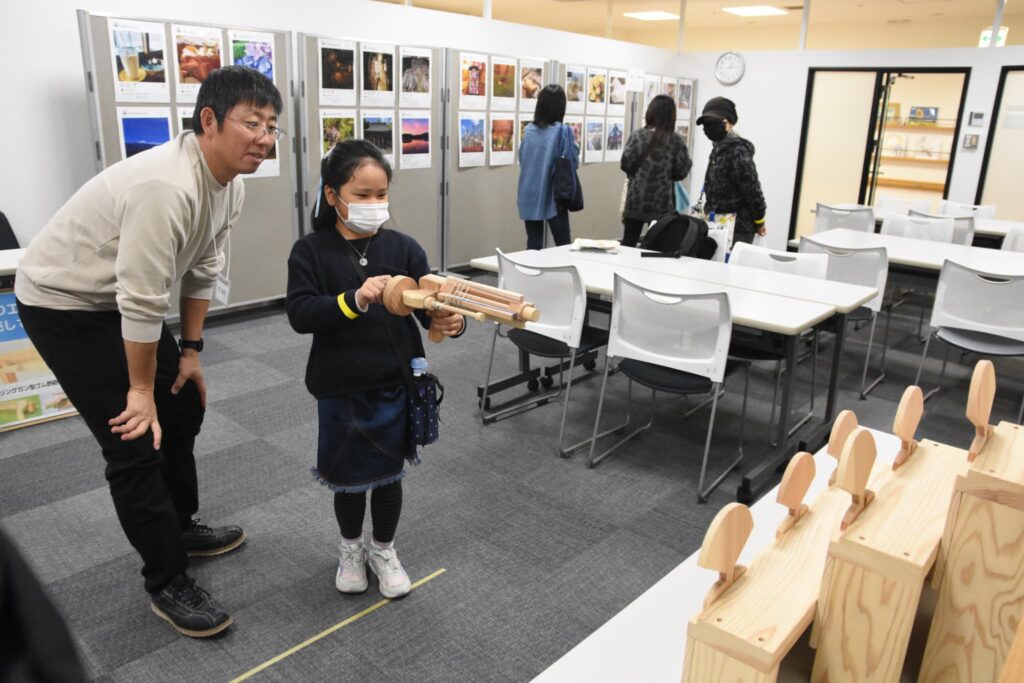 ゴム鉄砲で射的に挑戦する子ども