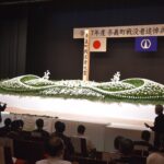 献花台に白菊を手向ける参列者
