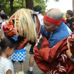 獅子舞にかまれる子ども