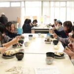 一緒に食事を楽しむ高校生と「すみれ会」のお年寄りたち