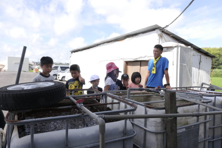 バクチャーで動物のフンを浄化する特殊な装置を見る子どもたち=岡山県津山市で