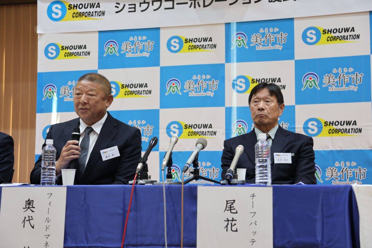 新体制発表会で抱負を述べる奥代恭一監督（左）と尾花高夫投手コーチ=岡山県美作市で