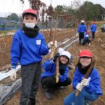 取れた自然薯を手に笑顔の児童=岡山県津山市で