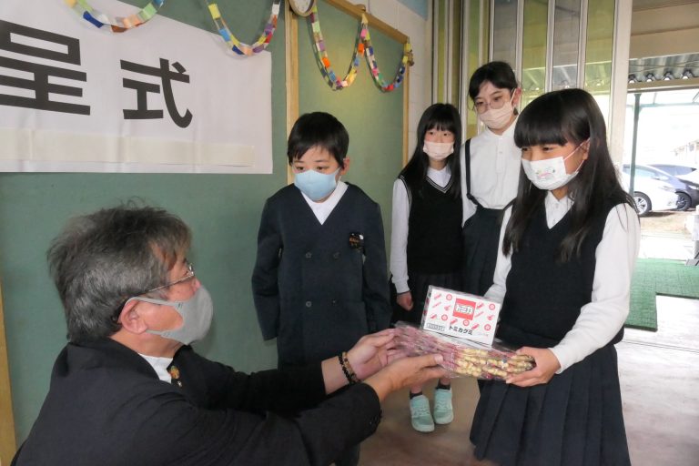 駄菓子を受け取るさらっこ児童クラブの子どもたち