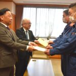 津山圏域少年女性防火委員会と美作市危険物安全協会の事務局長に目録を手渡す苅田支部長ら