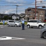 手信号で車を誘導する津山署員=岡山県津山市で