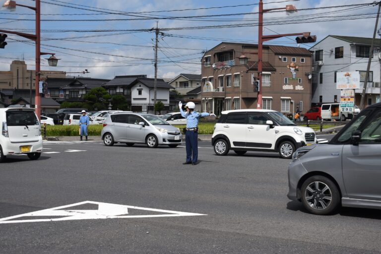 手信号で車を誘導する津山署員=岡山県津山市で