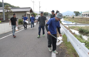 香々美川沿いの道路を清掃する同商工会青年部メンバーら＝岡山県鏡野町で