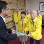 冊子を手渡す草地会長ら=岡山県津山市で