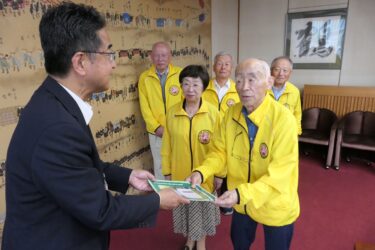 冊子を手渡す草地会長ら=岡山県津山市で