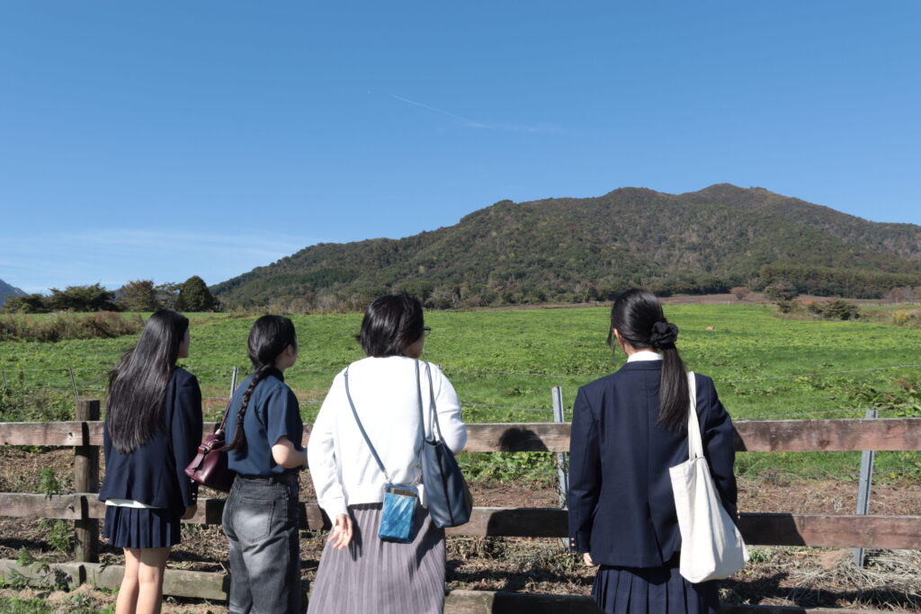 蒜山の山並みや牧草地を眺める参加者ら