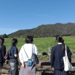 蒜山の山並みや牧草地を眺める参加者ら