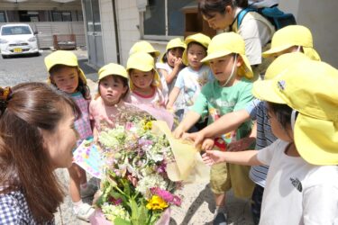 花束を社員に手渡す園児たち=岡山県津山市で