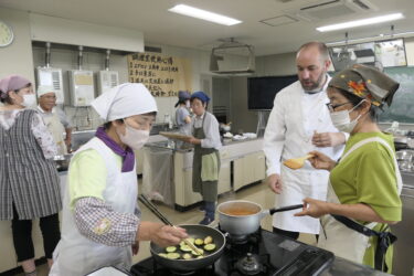 ラファエルさんに手順を教わりながら調理する参加者=岡山県奈義町で