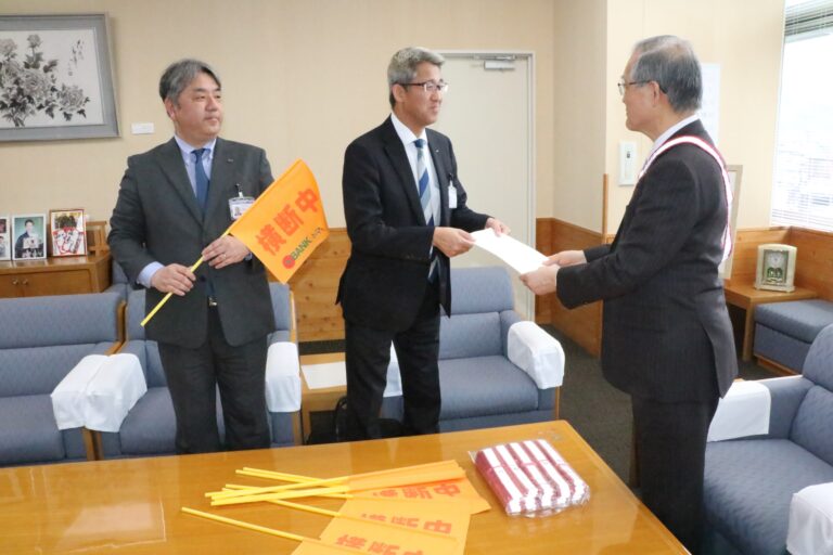 市長に横断旗を贈る金光支店長（左）と加藤支店長（中央）=岡山県真庭市で