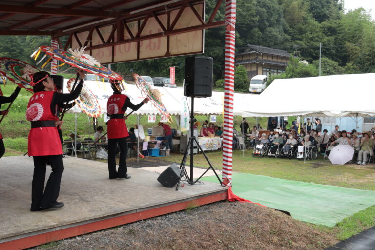 ステージで披露される傘踊りを見て楽しむ人たち=岡山県久米南町で