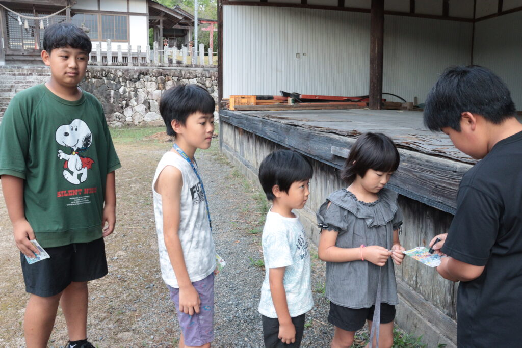ラジオ体操を終え、出席カードに印鑑を押してもらう子どもたち