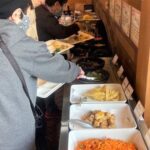 副菜バイキングの料理を選ぶ人たち