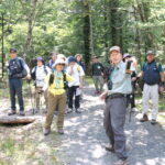 森林インストラクターの案内で園内を散策する参加者＝岡山県鏡野町で