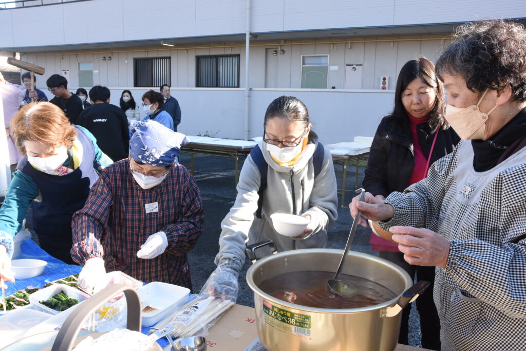 あつあつのおしるこを振る舞う参加者ら