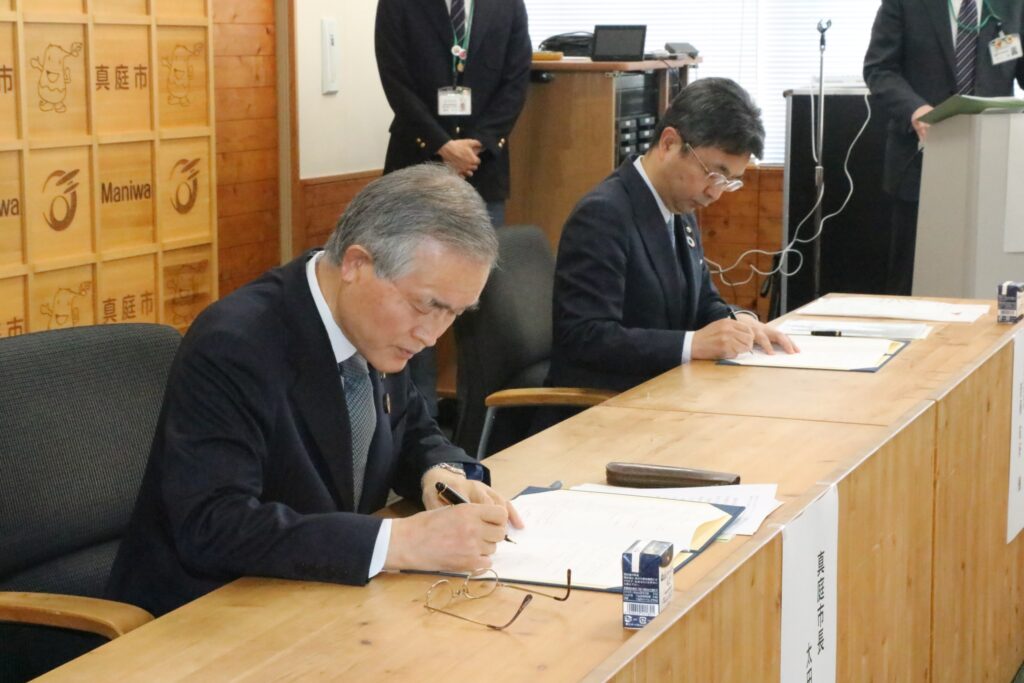 協定書に署名する太田市長と斎藤社長