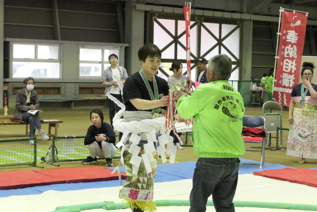 優勝トロフィーを受け取る光岡さん