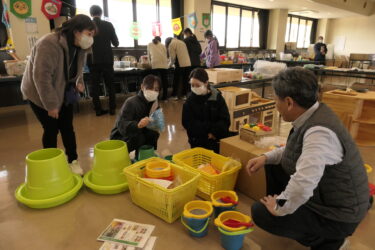 社員の説明を聞きながら商品を手にする保育士ら=岡山県津山市で