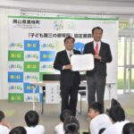 協定書を手にする青野町長（左）と菅原理事長=岡山県美咲町で