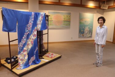 会場に並ぶ染色作品と赤松さん=岡山県津山市で