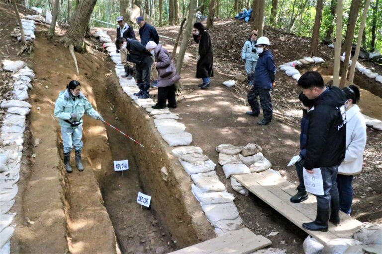 高野山根１号墳の調査区で説明を受ける参加者=岡山県津山市で