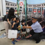 髙橋駅長から記念品を受け取る桝本さん一家