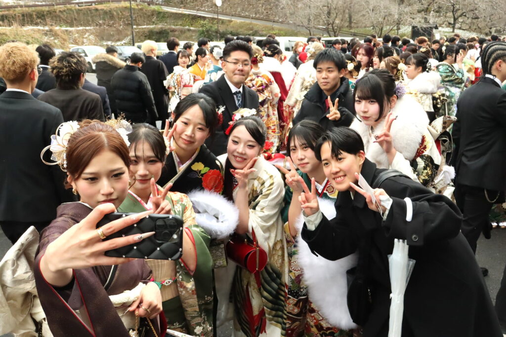 再会した友人たちと記念撮影をする若者たち