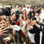 再会した友人たちと記念撮影をする若者たち