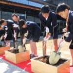 桜などの苗木を植え付ける弓削小学校の６年生や町長ら=岡山県久米南町で