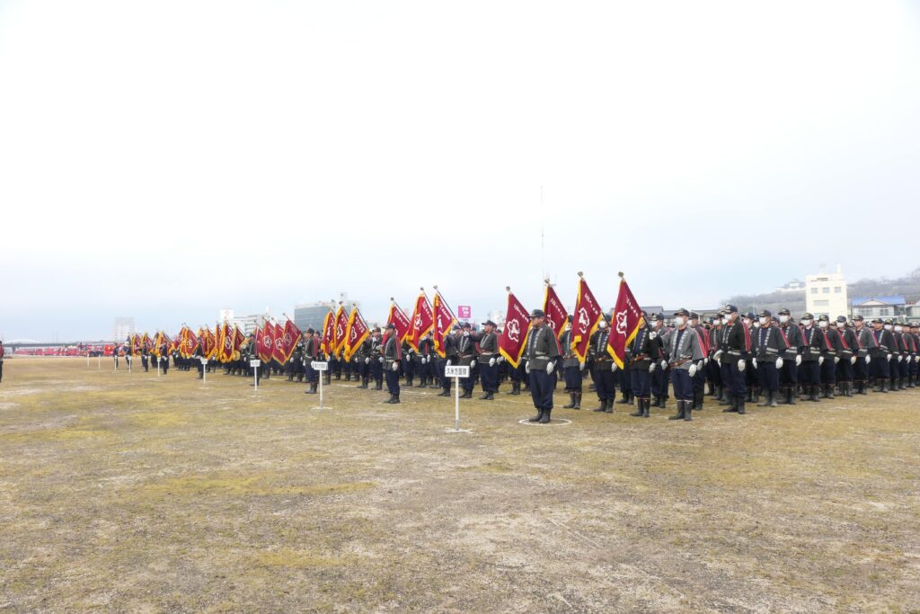 吉井川河岸緑地公園南岸に整列した消防団員ら