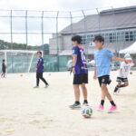 新しいゴールが設置されたグラウンドで、岡山湯郷ベルの選手とサッカーを楽しむ子どもたち＝岡山県津山市で