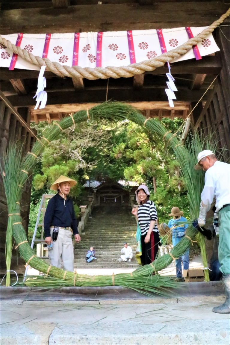 夏越祭の茅の輪を神門に据え付ける氏子ら