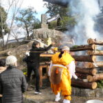 護摩壇に護摩木をくべる参拝客