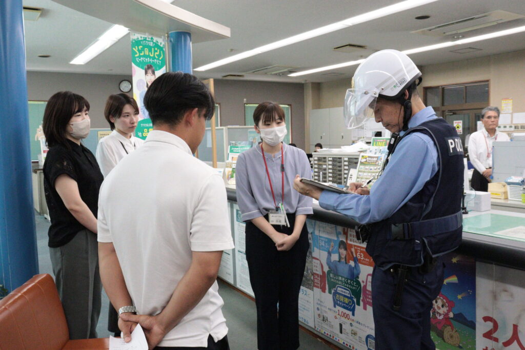 駆け付けた署員に犯人の特徴を説明する職員たち