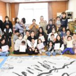 完成した書アートと手形足形アートに笑顔を見せる参加者=岡山県津山市で